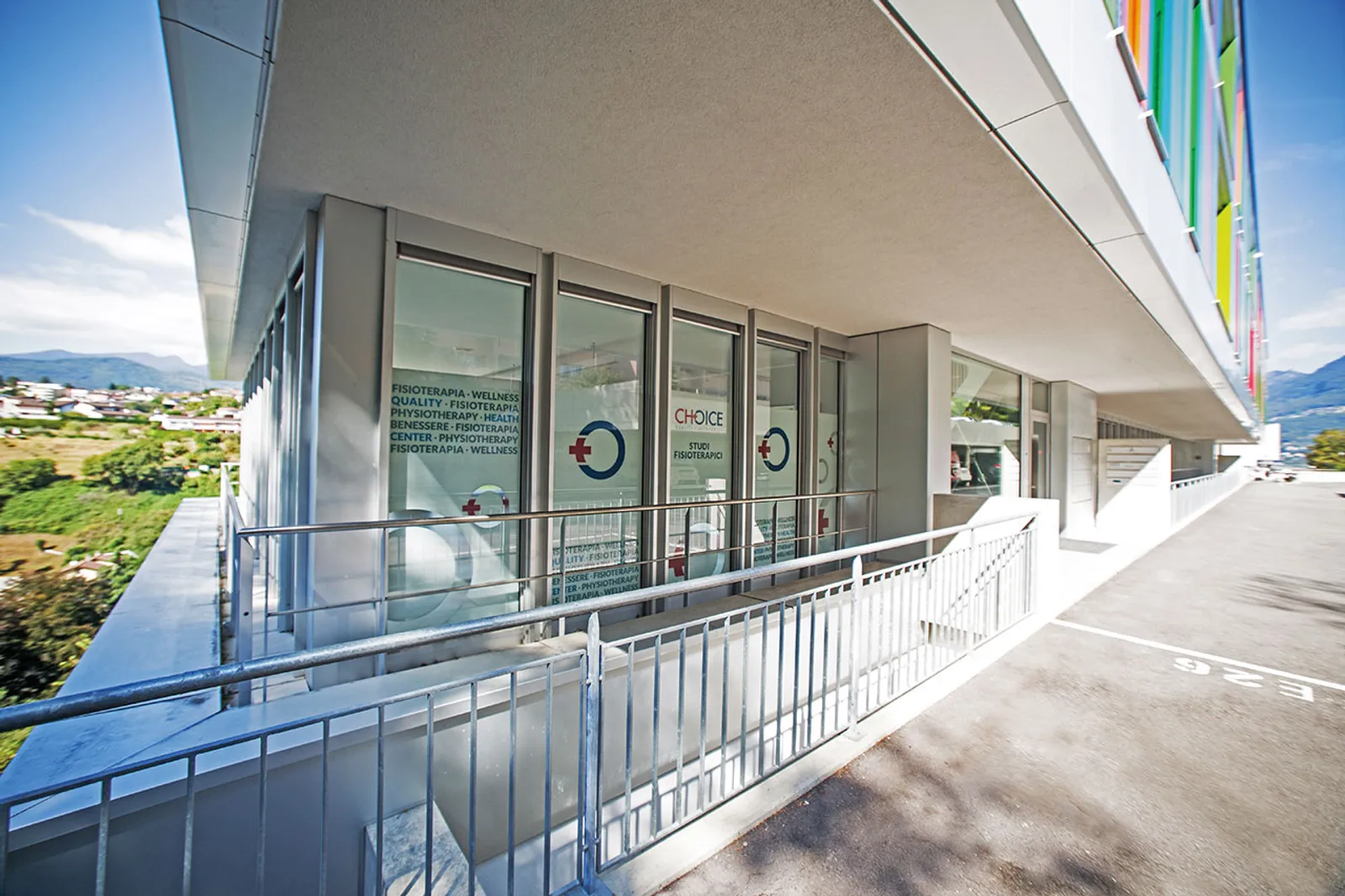 L’ingresso di Choice Health Center: accesso senza barriere al pianterreno della Residenza ai Faggi, a Pazzallo, con le montagne del Luganese sullo sfondo