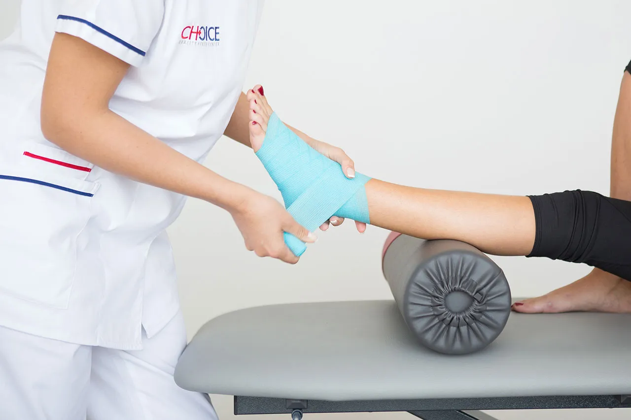 Fisioterapista Choice tratta la caviglia di una paziente sul lettino